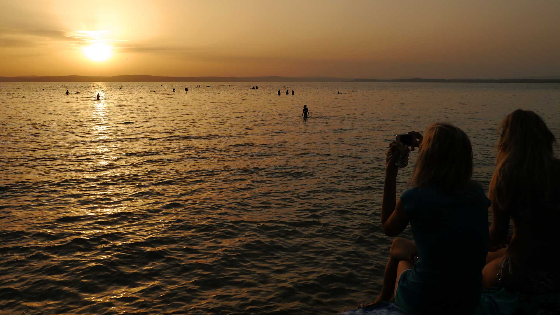 Alkony, naplementére várakozók a Balaton déli partján