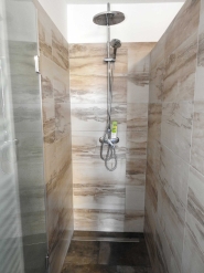 A képen, az eladó balatoni lakóház szuterénjében lévő zuhanyozó látható.